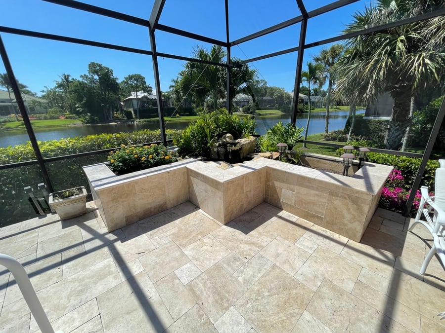 Screened lanai with travertine floor and built-in planter wall