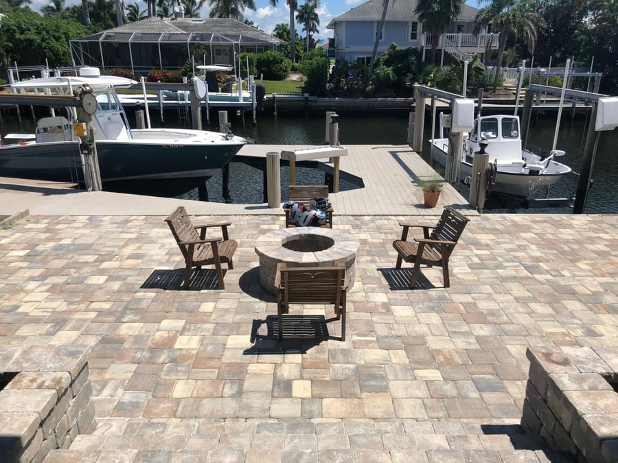 Dockside paver patio with round fire pit facing the canal