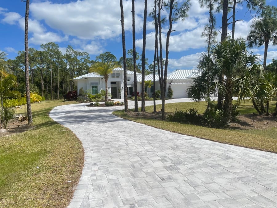White plank paver driveway curving to a coastal estate