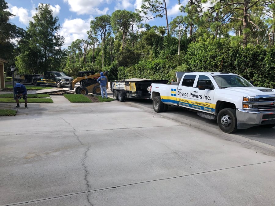 Crew and skid steer removing an old concrete driveway