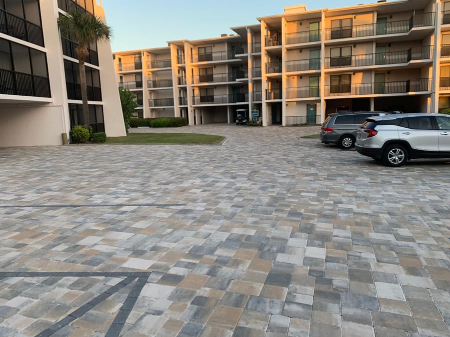 Condo courtyard parking court in blended gray and tan pavers at sunset