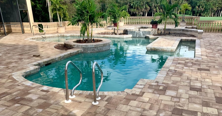 Estate paver pool deck with spa, planters and palms