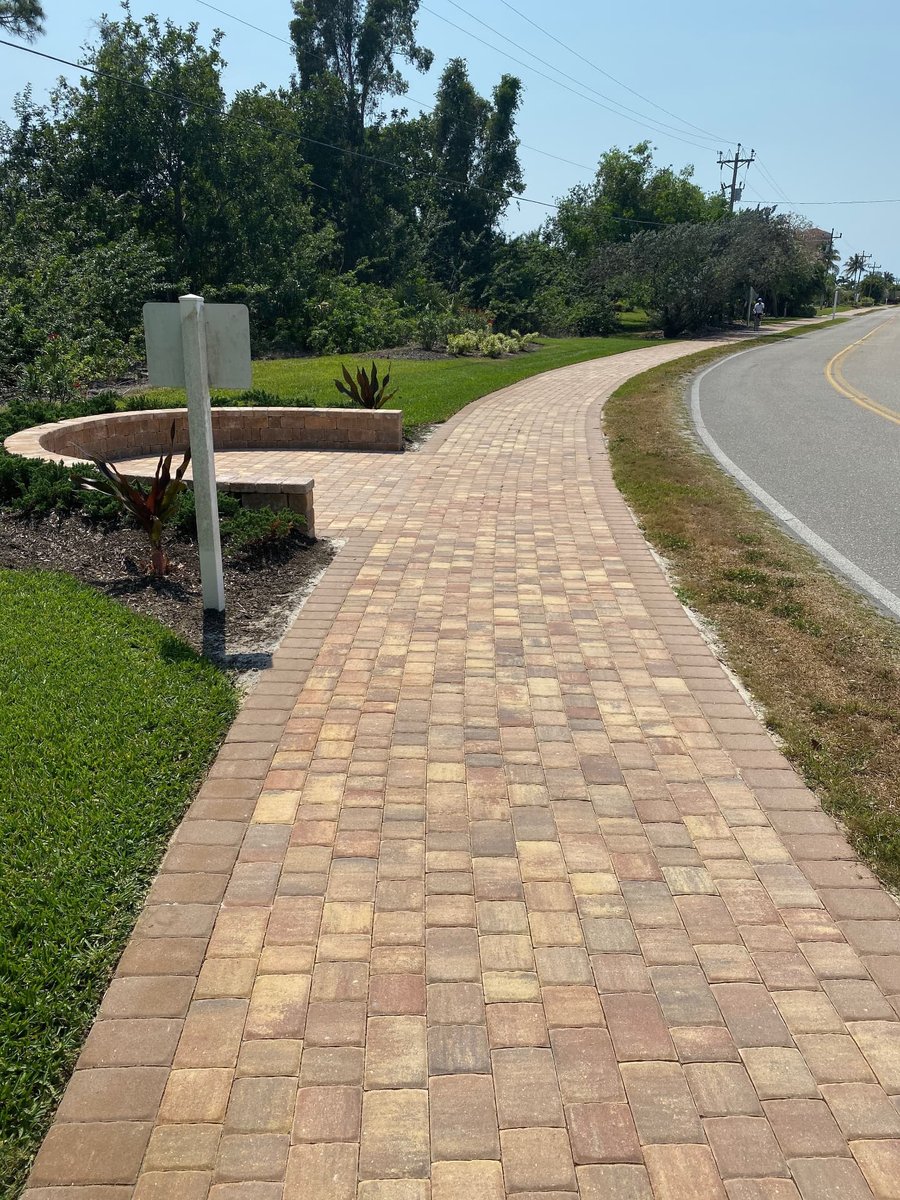 Long curved walkway with a seat wall bench along a community road