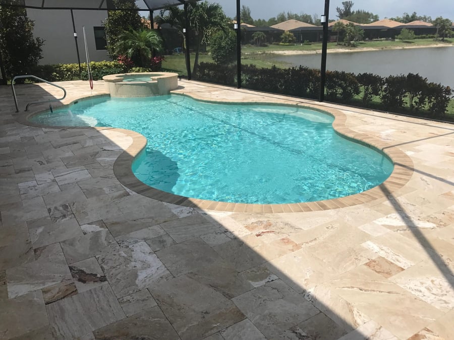 Travertine deck around a freeform pool with lake views