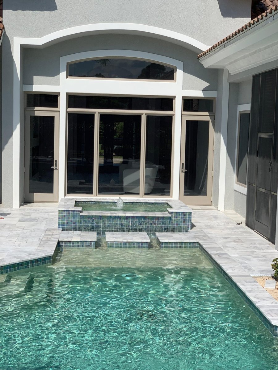 Marble courtyard pool with raised spa and tile spillover