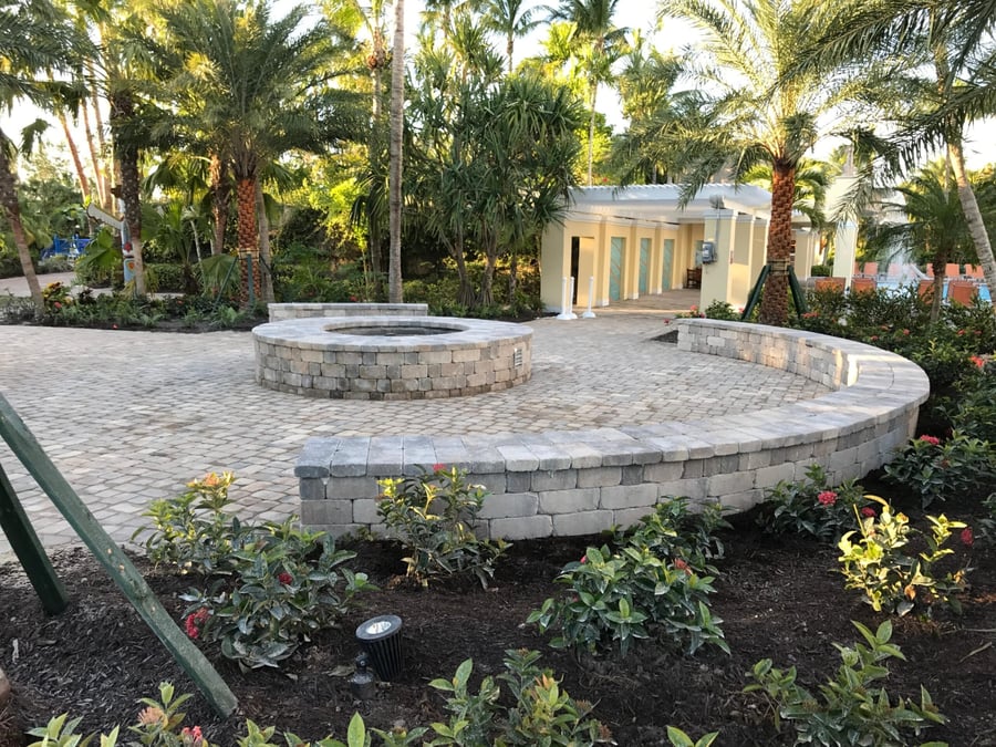 Resort fire pit with curved paver seat wall and patio