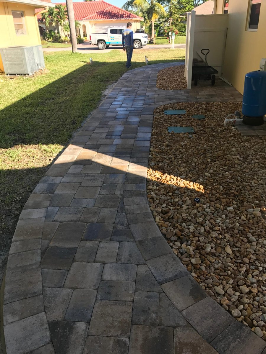 Curved paver walkway leading to travertine entry steps