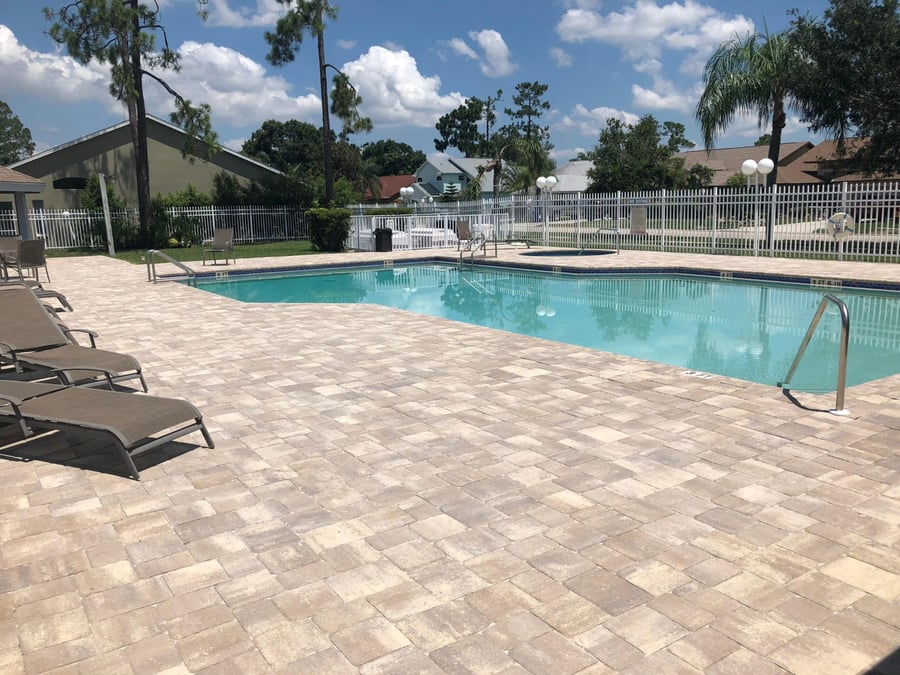 HOA pool deck in tumbled pavers with spa