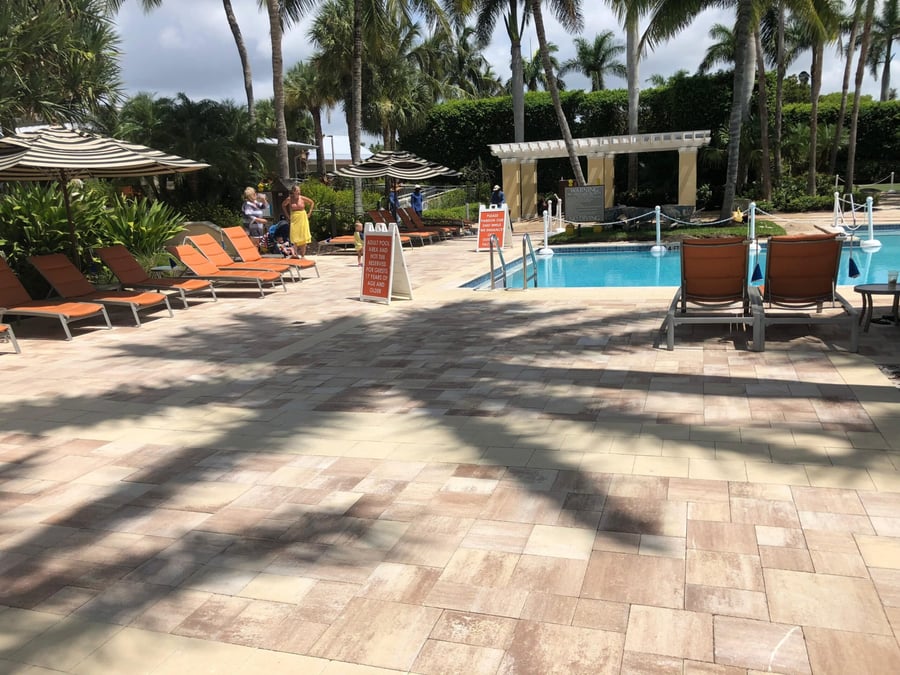 Resort pool deck in blended pavers with umbrellas and loungers