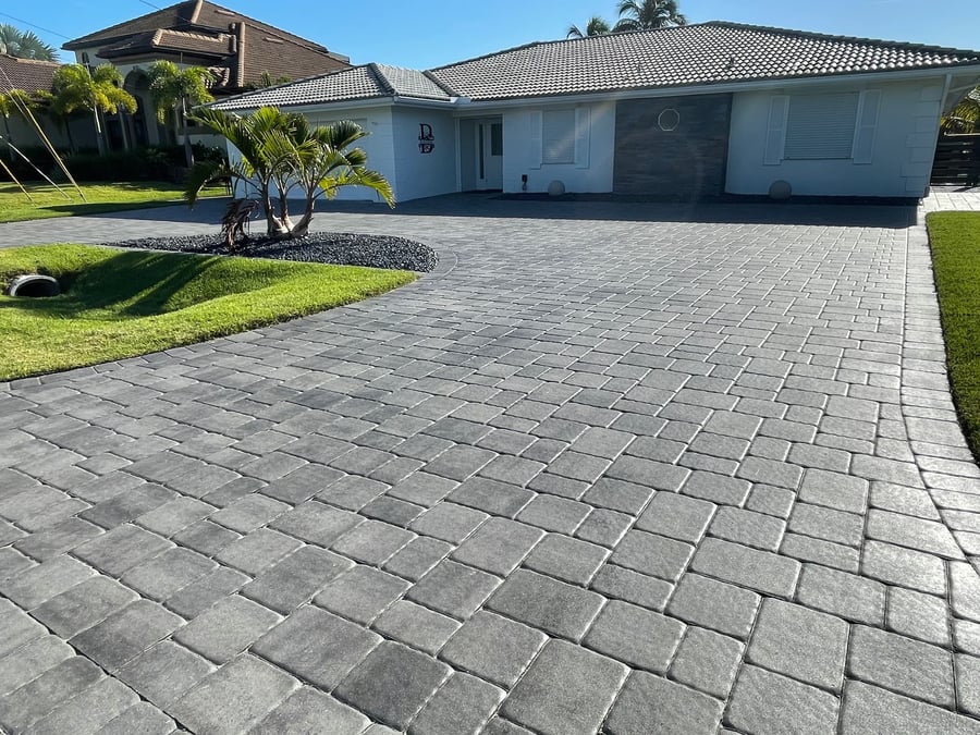 Newly sealed gray paver driveway at a coastal home