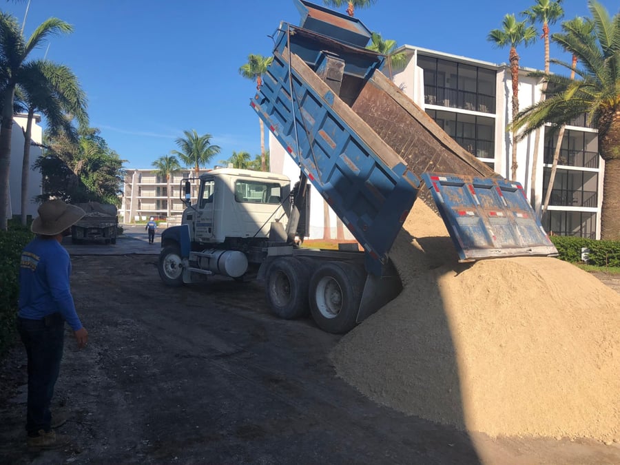 Bastos dump truck delivering base sand at a condominium project