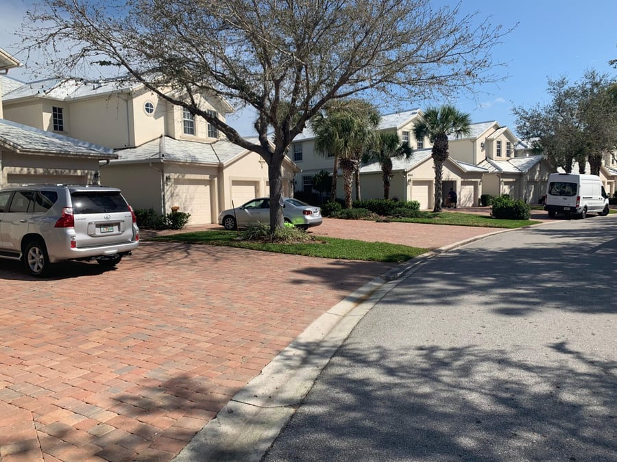 Curved brick paver driveways along a townhome community street