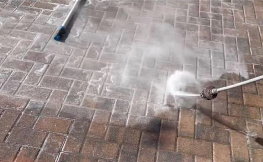 Surface cleaner pressure washing a brick paver driveway