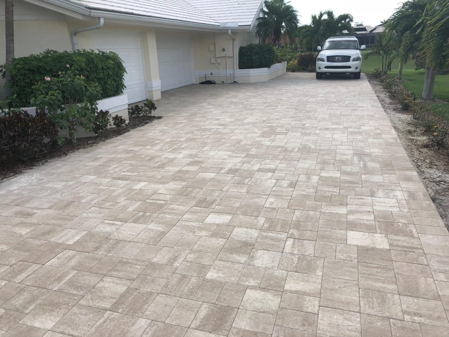 Ivory paver driveway leading to a two car garage
