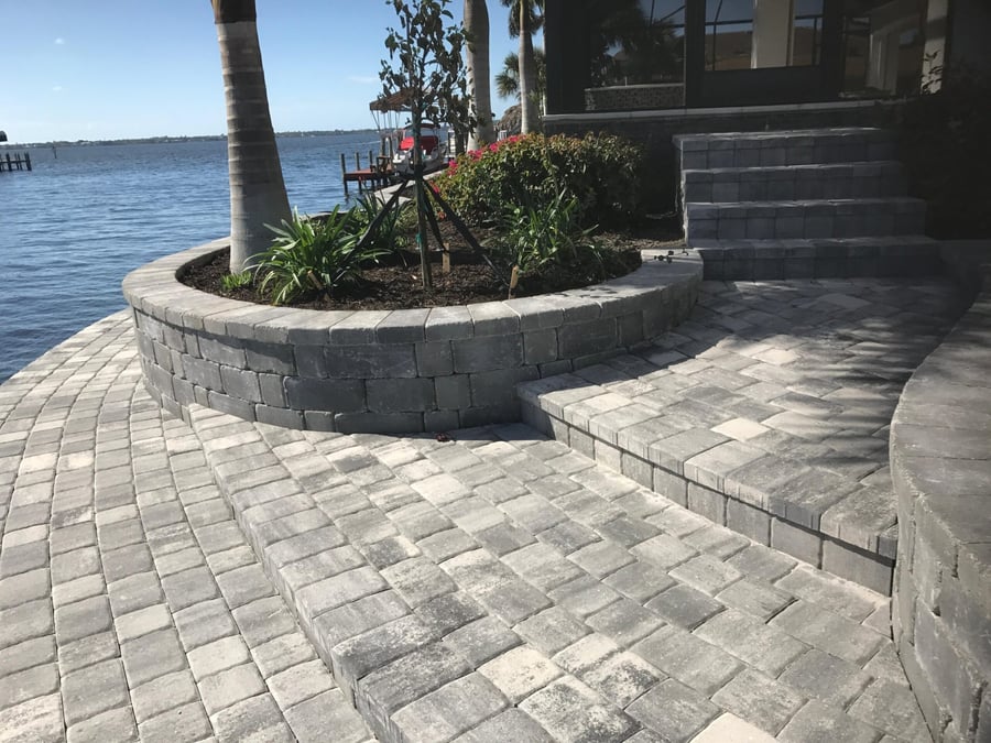 Waterfront cobble patio with charcoal planter wall and steps