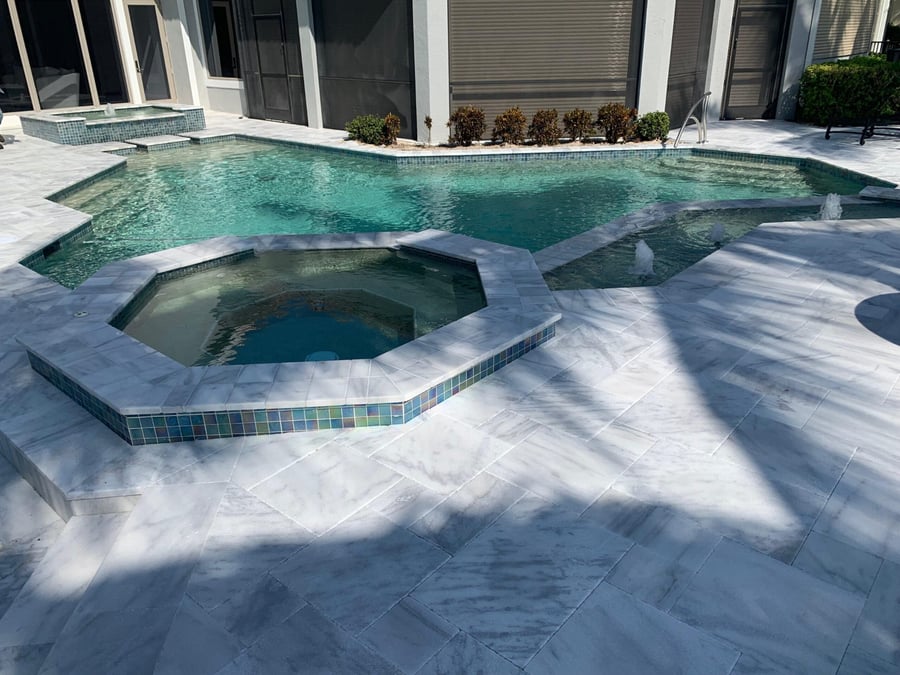 Marble pool deck with octagonal spa and iridescent mosaic tile