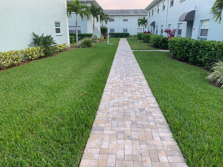 Straight paver walkway between lawns at a condominium community
