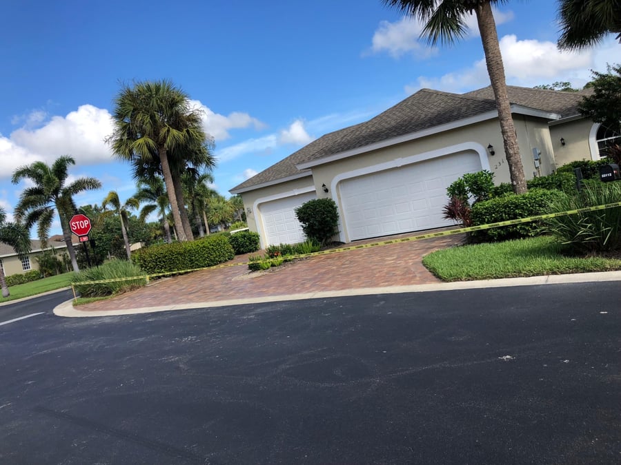Paver driveway on a corner lot with palm landscaping