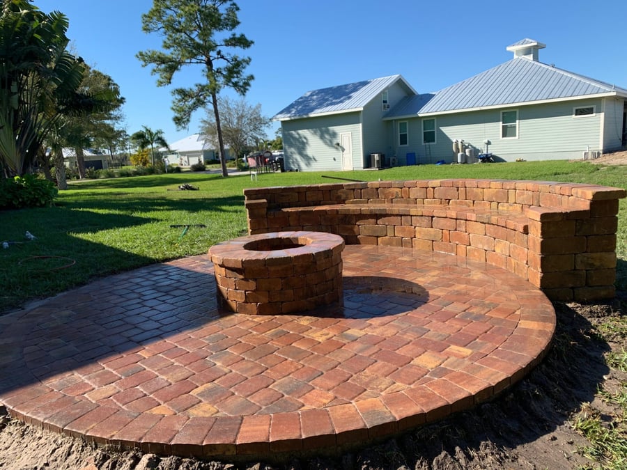 Circular brick patio with fire pit and curved seat wall