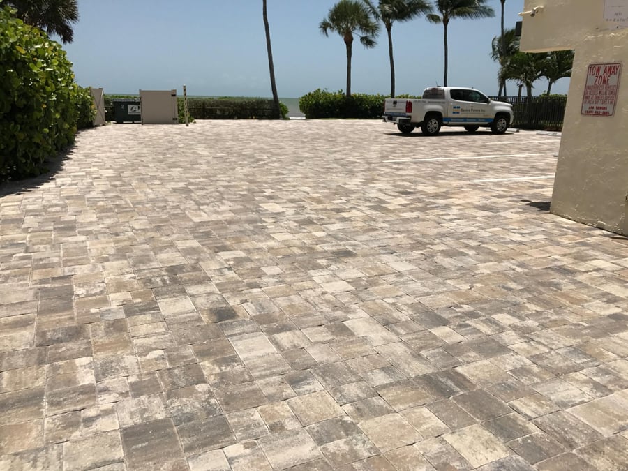 Beachfront condominium parking area in travertine-toned pavers