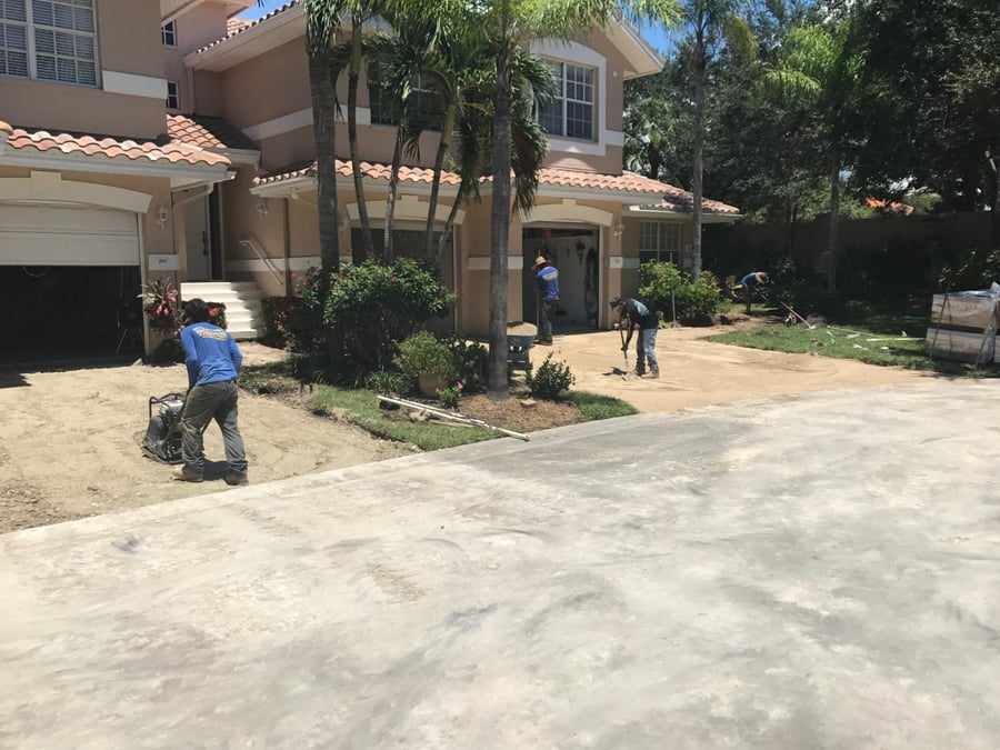 Crew screeding sand for a condominium driveway installation