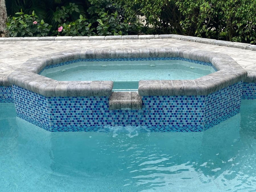 Travertine spa coping with mosaic tile spillover