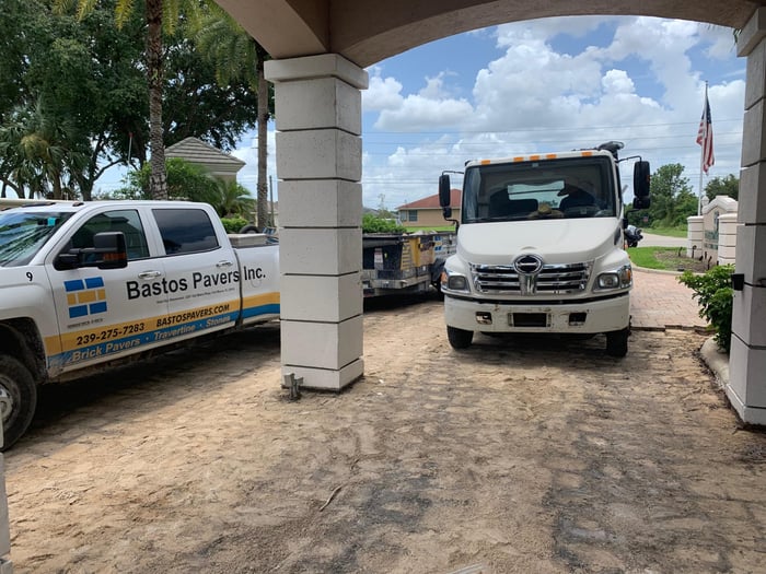 Golf club entry paver installation with crew and trucks