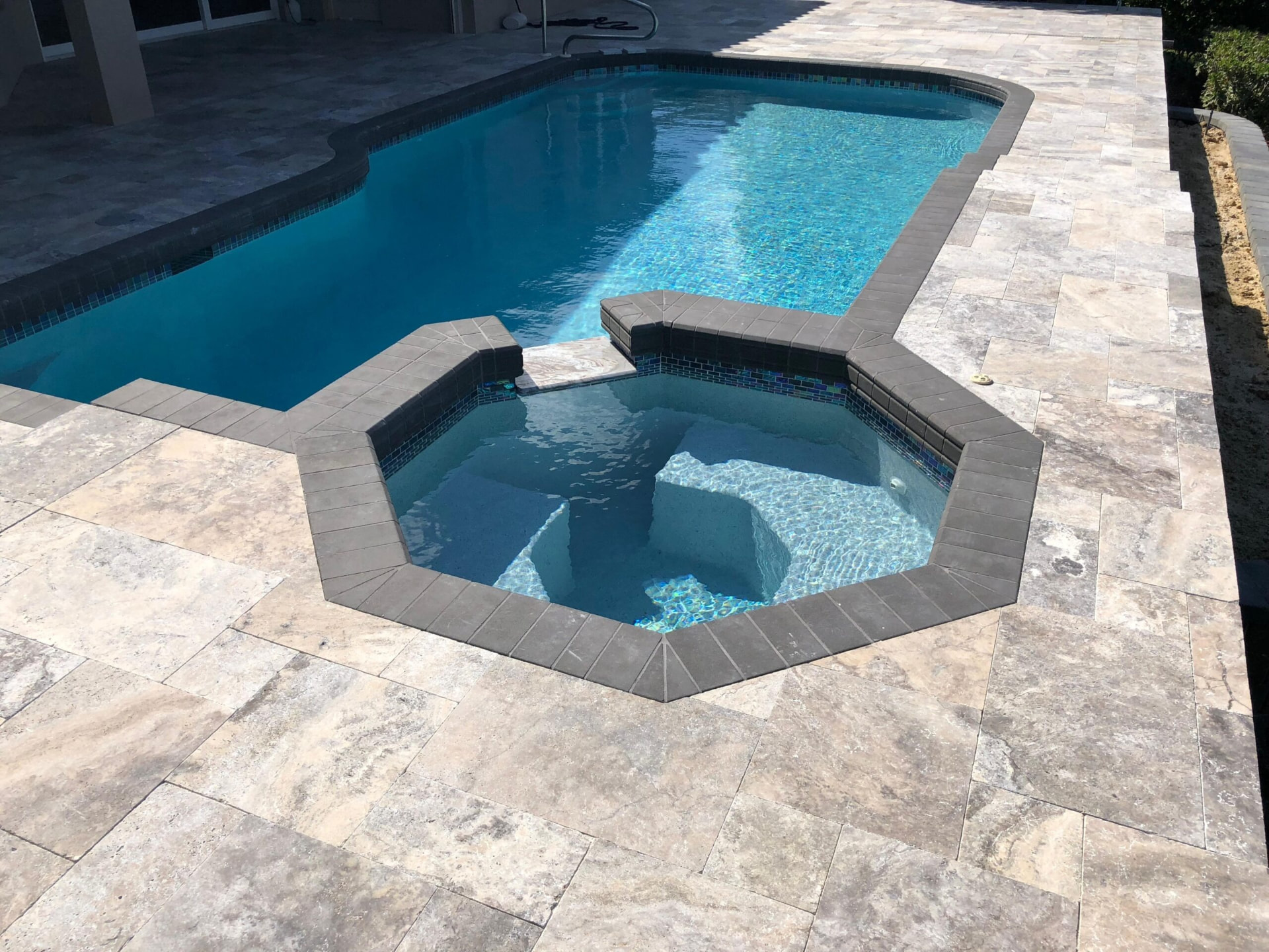 Silver travertine pool deck with octagonal spa