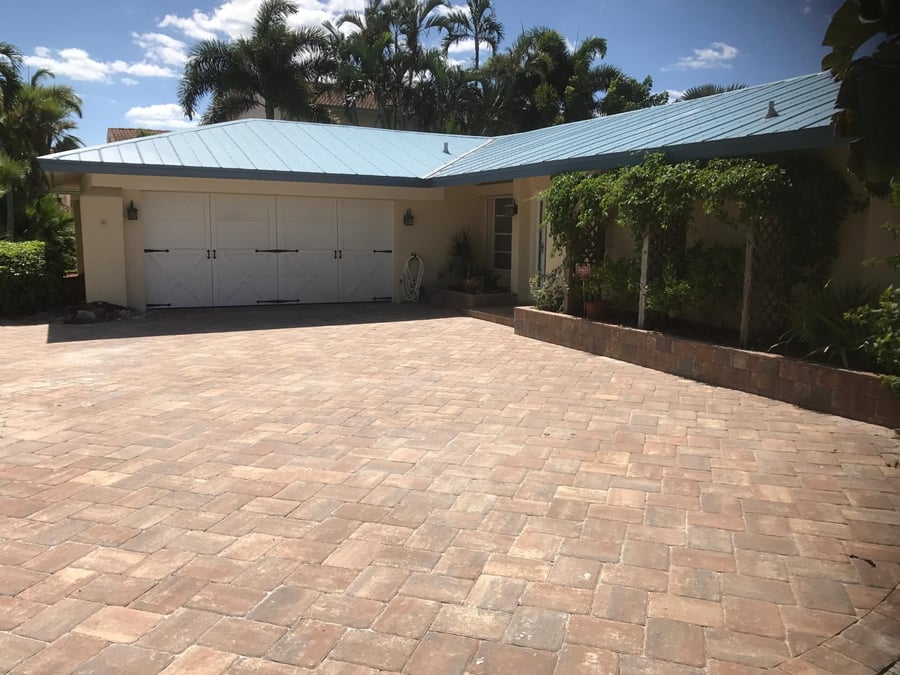 Coral tumbled paver driveway at a coastal home
