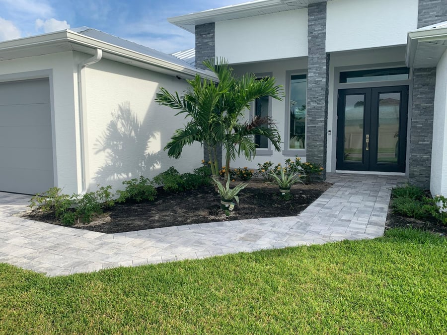 Silver travertine entry walkway wrapping a new build