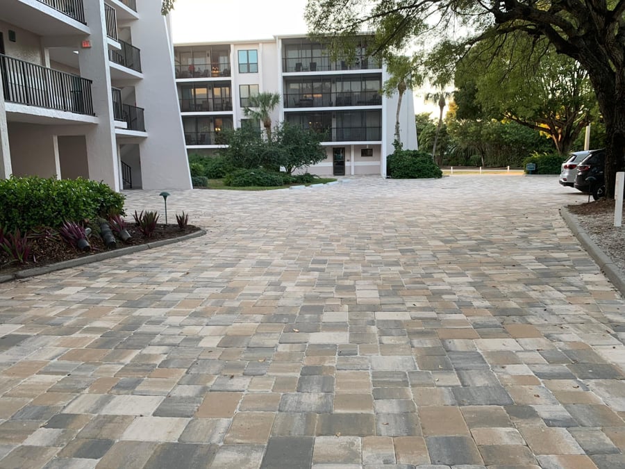 Tumbled paver courtyard drive between condominium buildings at dusk