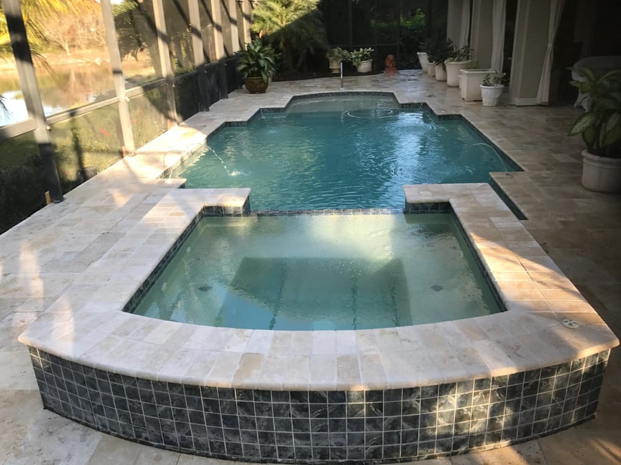 Travertine pool deck with raised spa and spillover