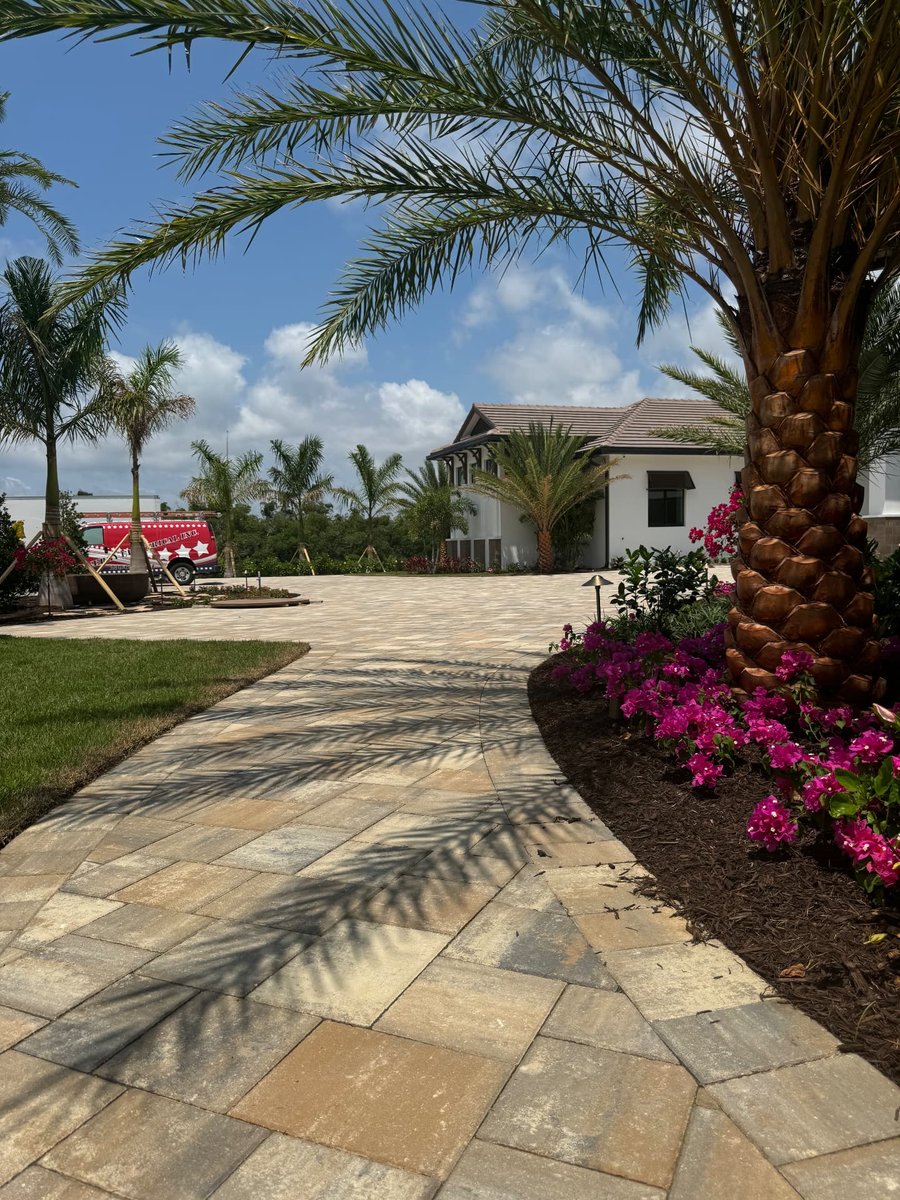 Curved paver walkway with bougainvillea leading to a home entry