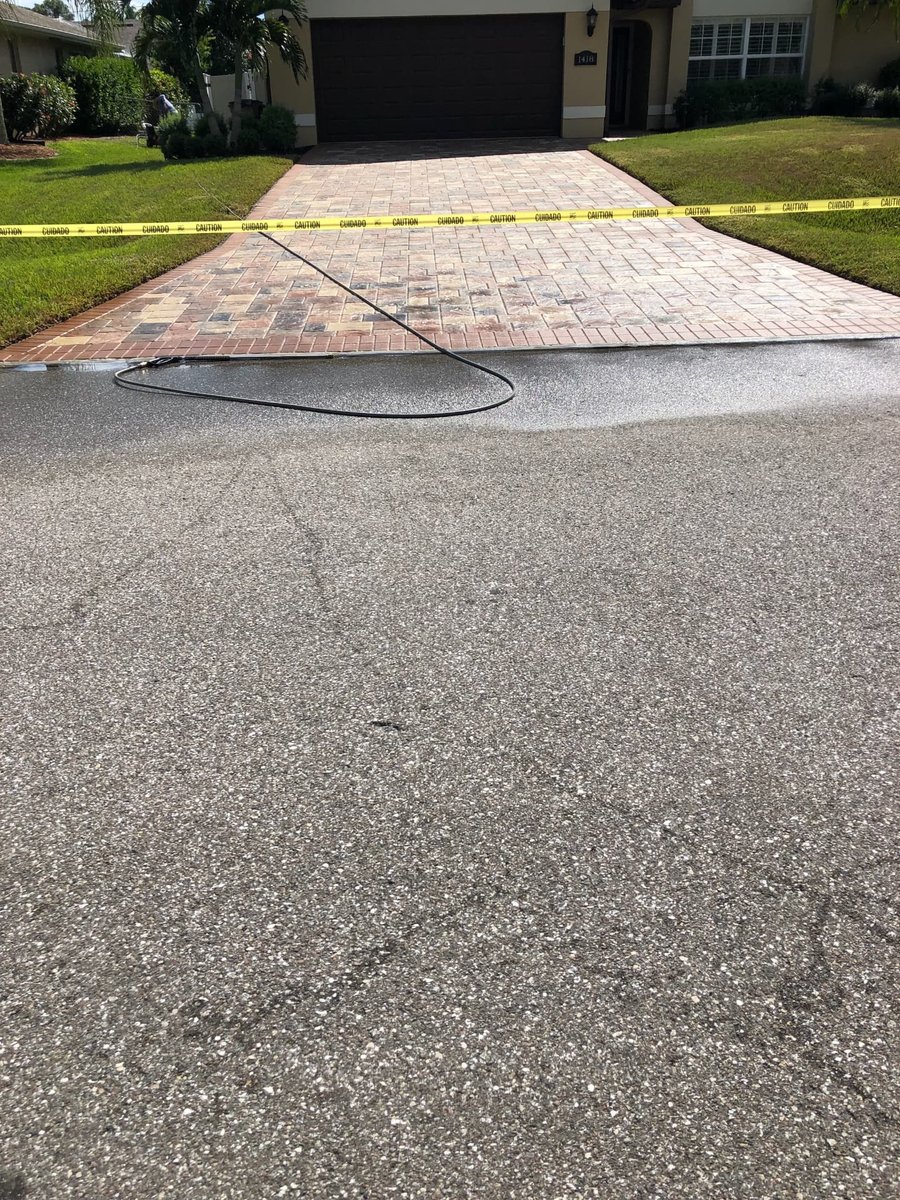 Freshly sealed paver driveway roped off with caution tape