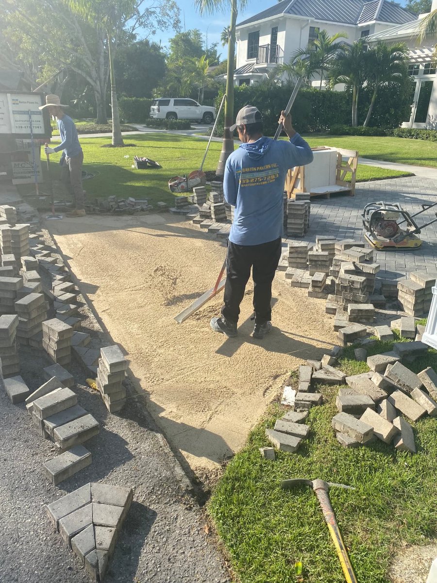 Crew screeding sand base for a paver driveway repair