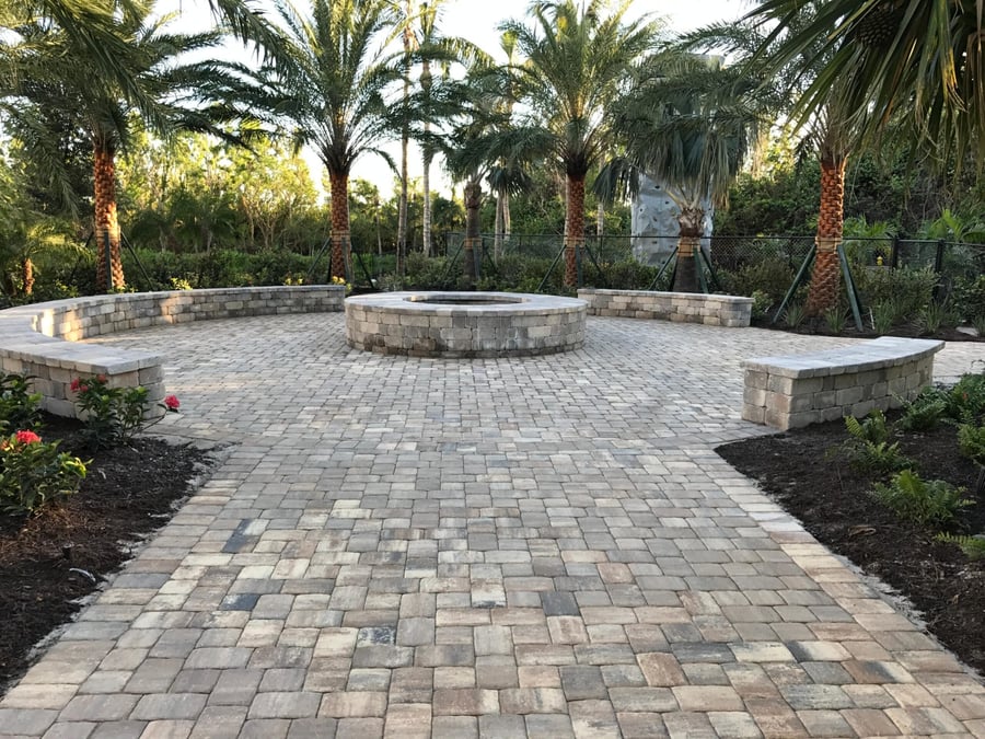 Paver fire pit plaza with curved bench walls at golden hour