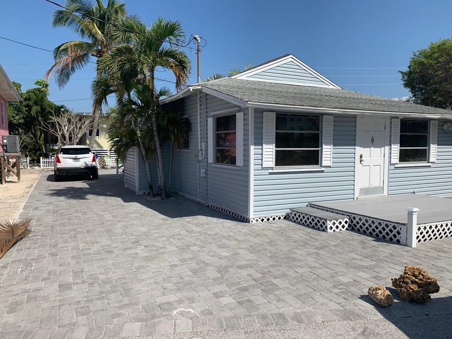 Gray paver driveway wrapping around a coastal cottage
