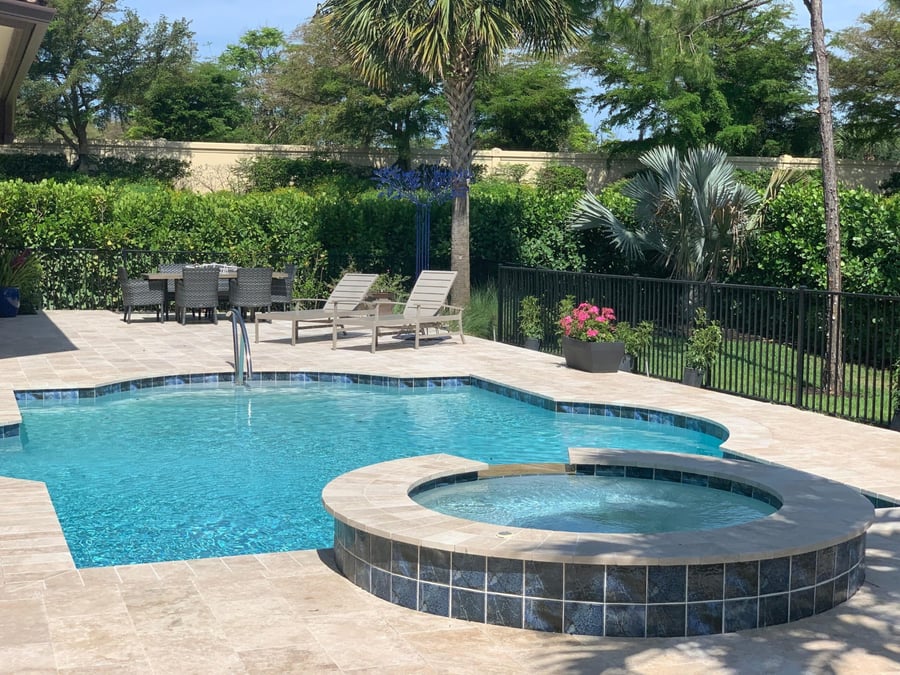Travertine pool deck with round spa and lounge area