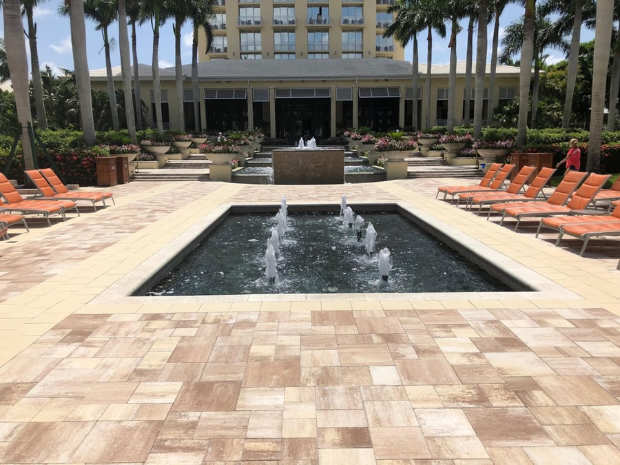 Resort courtyard plaza with fountain and banded travertine paving
