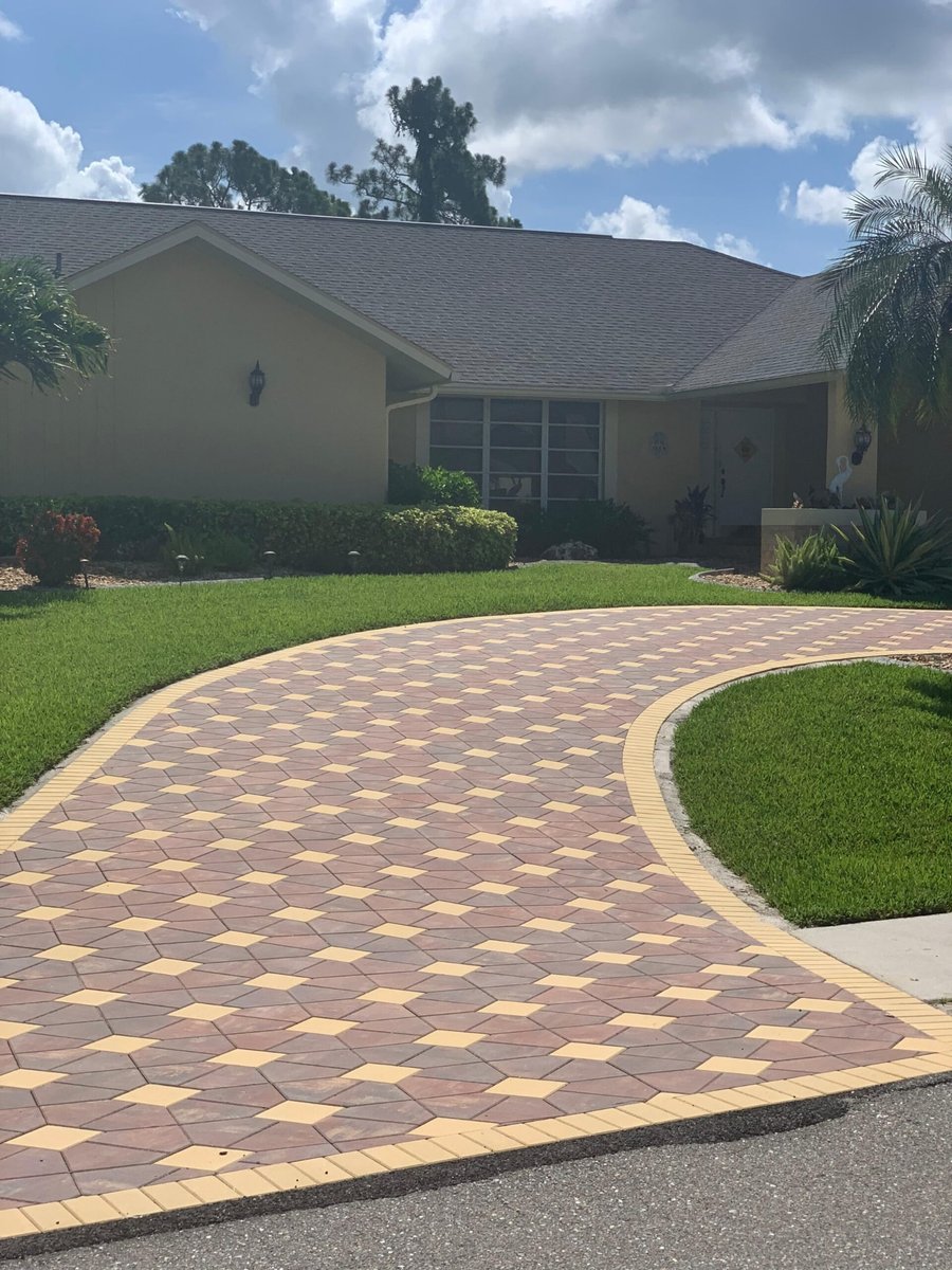 Patterned red and yellow paver driveway with banding