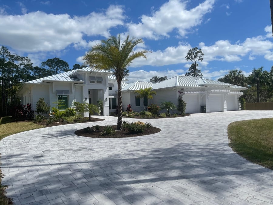 Wide circular paver driveway at a white coastal estate