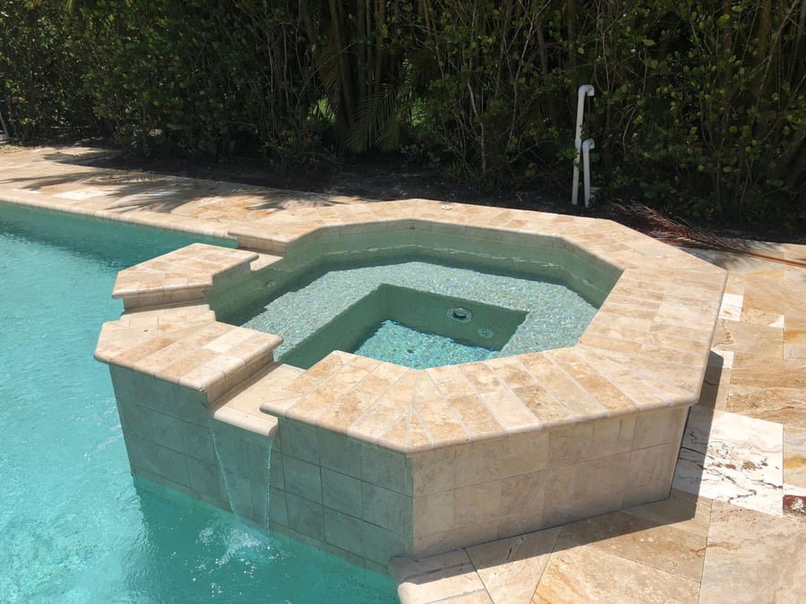 Travertine spa with spillover and pool entry steps