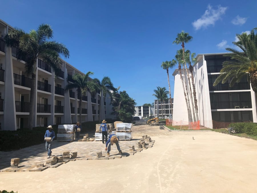 Crew laying pavers for a condominium parking area