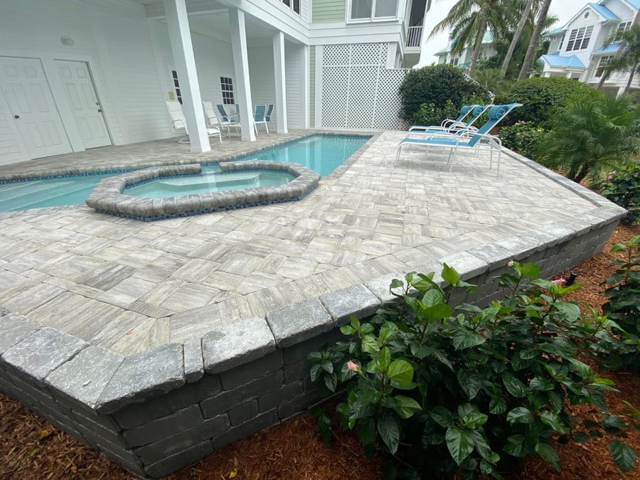 Raised paver pool deck with block retaining wall and spa