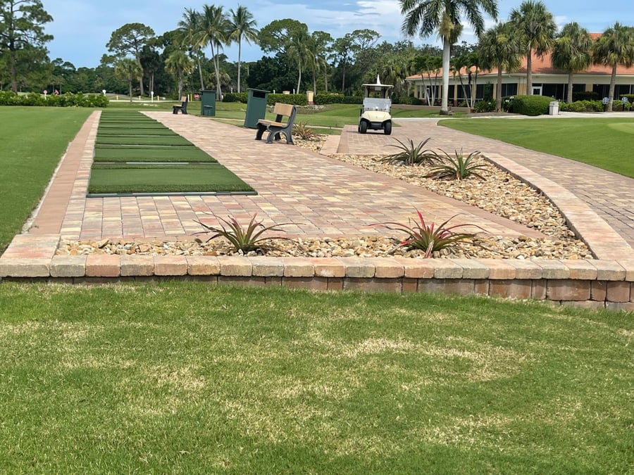 Paver walkway and raised planter wall at a golf club driving range