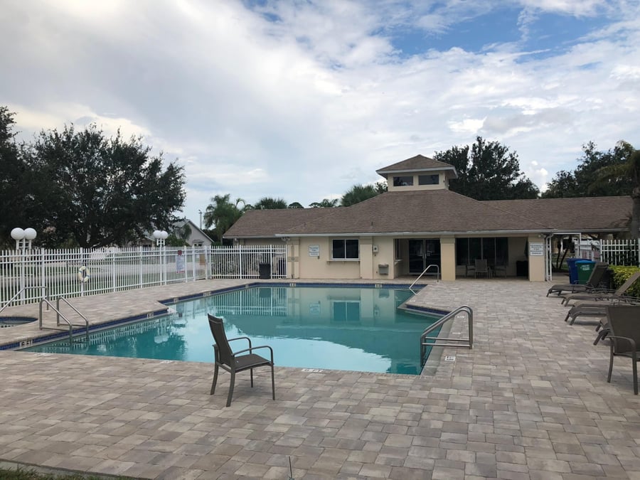 Clubhouse pool deck in blended pavers beside the community pool