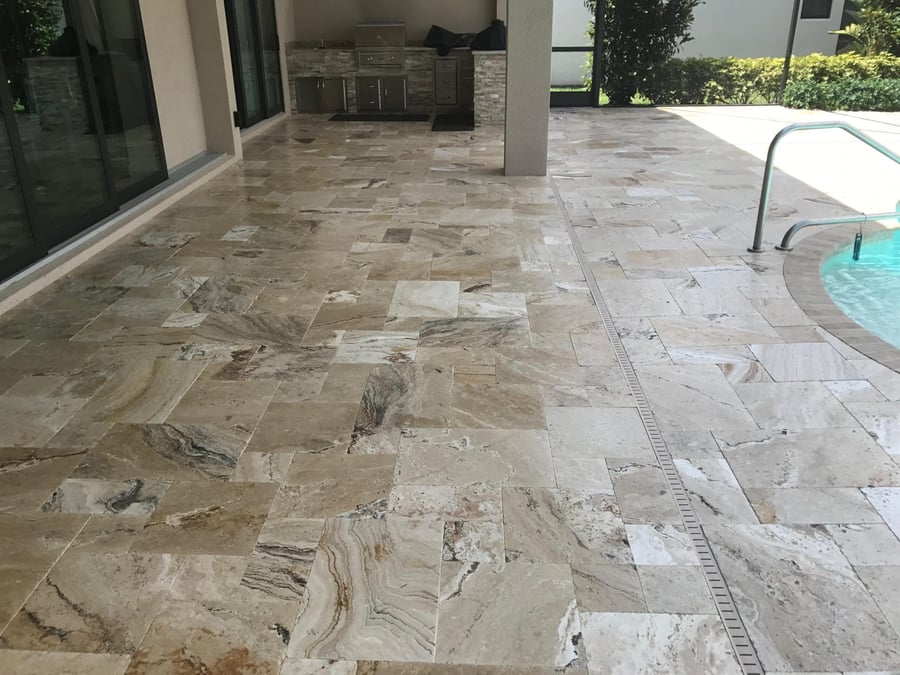 Picasso travertine lanai with outdoor kitchen and pool edge