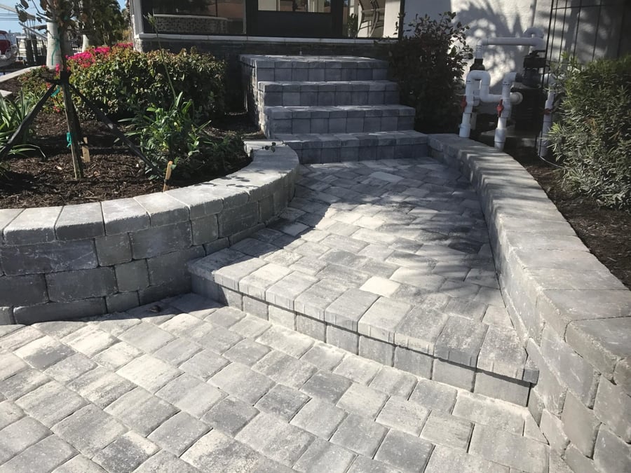 Gray paver steps, landing and curved walls at a waterfront home